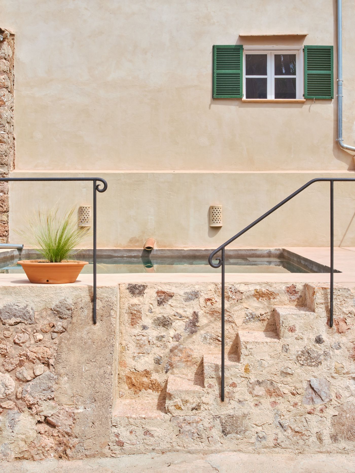 Stone steps leading down to the historic safareig, a traditional Mallorcan water cistern restored and adapted for swimming
