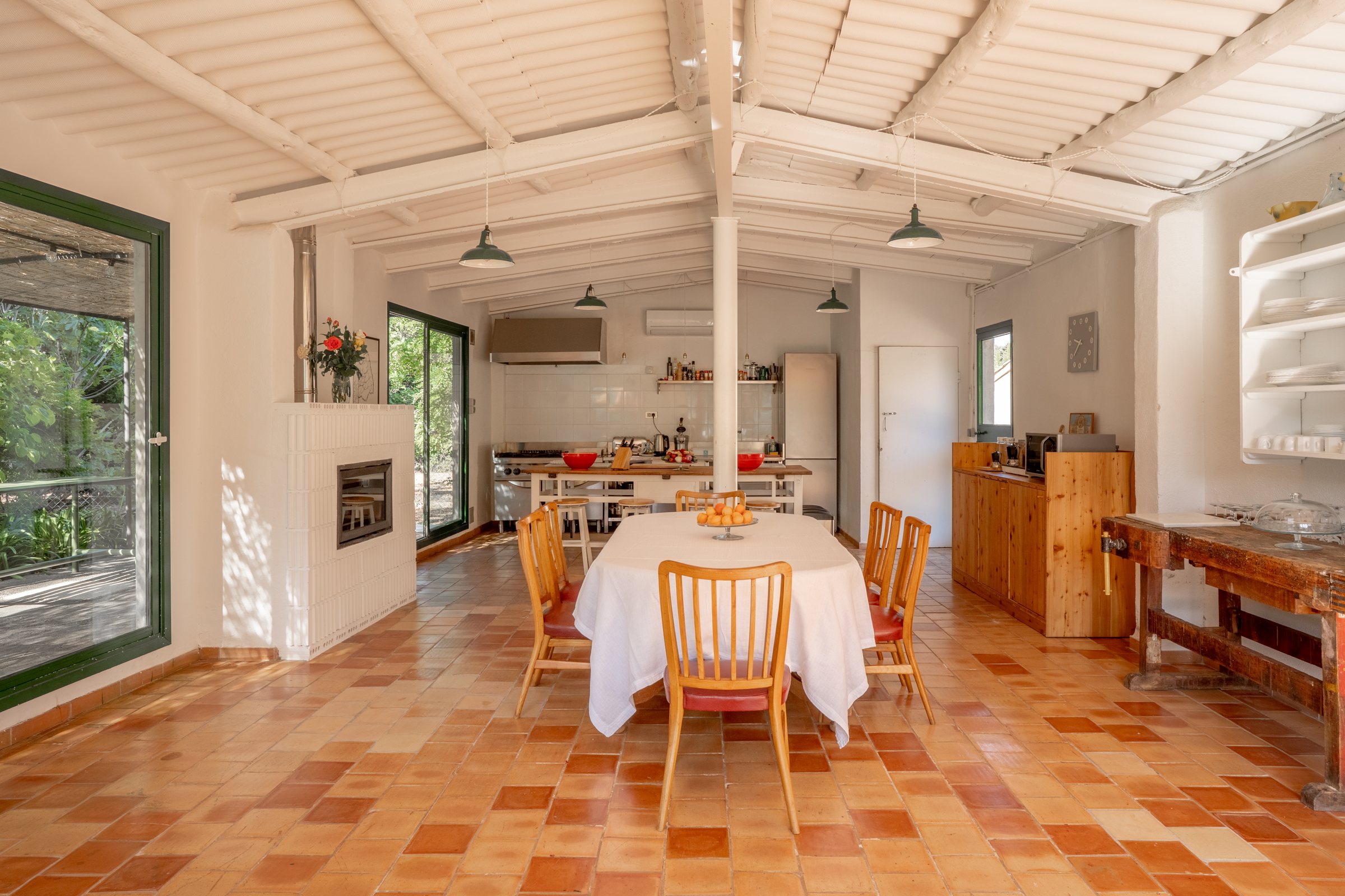 The studio kitchen and dining room, with green-framed windows open to the garden