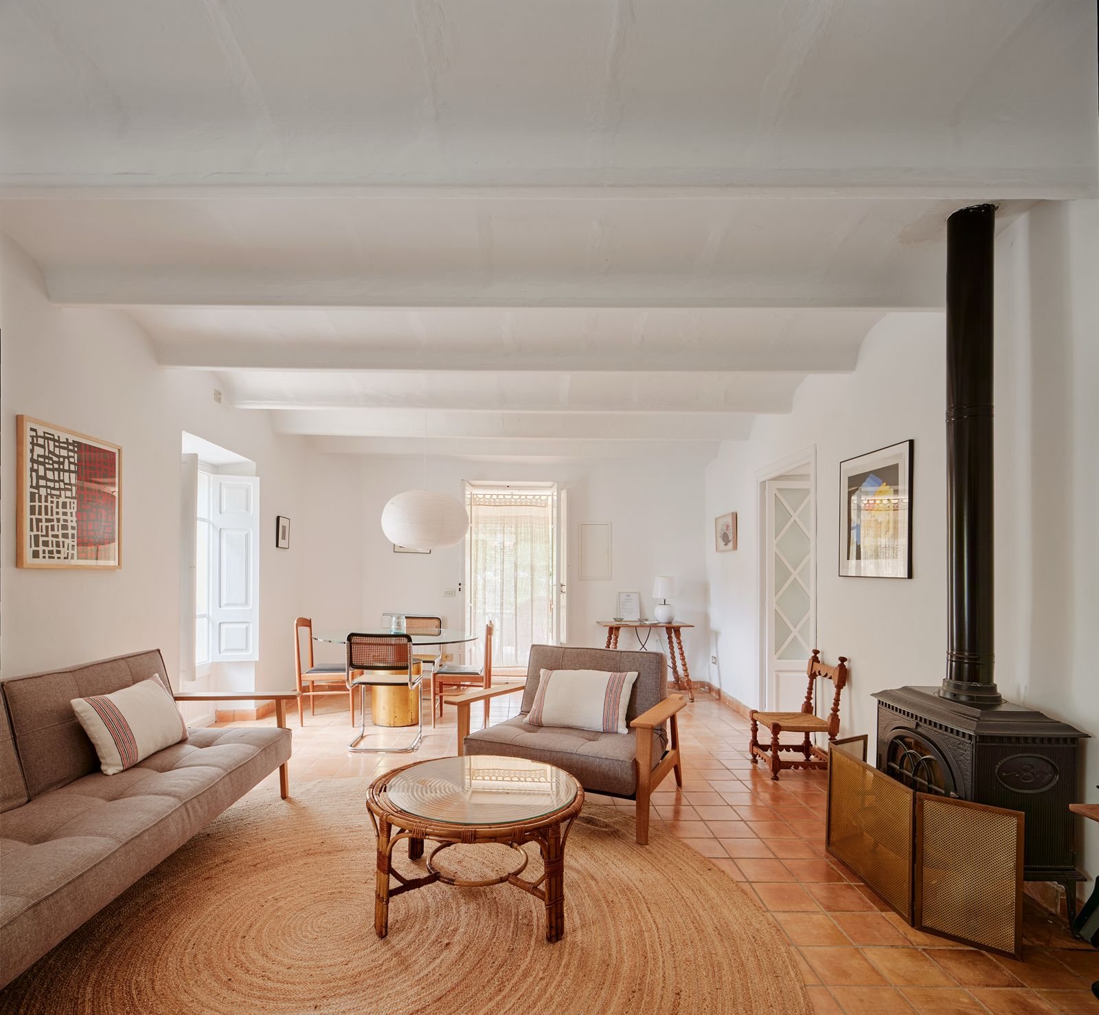 The main living room, with its wood-burning stove, sofas and jute rug